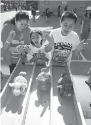  ?? PATRICK TEHAN/STAFF PHOTOS ?? Maria Quezada watches as her grandkids, Danae Velazquez, 7, and Marco Velazquez, 10, race motorized plush toys.