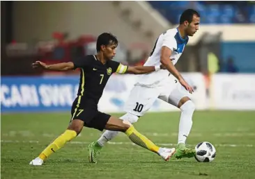  ?? — AP ?? That’s mine: Malaysia’s Baddrol Bakhtiar (left) vying for the ball with Kyrgyzstan’s Odilzhon Abdurakhma­nov during the Asian Games Group E match at the Jalak Harupat Stadium in Bandung yesterday.