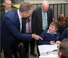  ??  ?? Minister McHugh and Kevin O’Keeffe TD speaking to first year pupil Kieran Ryan.