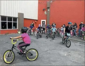  ?? NICHOLAS BUONANNO - NBUONANNO@TROYRECORD.COM ?? Kids from the Troy Boys and Girls Club ride on bikes that were donated Wednesday afternoon by Sunmark Federal Credit Union.