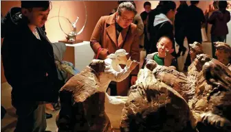  ?? PHOTOS PROVIDED AND BY JIANG DONG / CHINA DAILY ?? From left: Sculptures which reflect Chinese artists’ feelings about ethnic diversity are on show at the National Art Museum of China in Beijing. A work that depicts musicians of the Jing ethnic group by Huang Bingyi is on display.