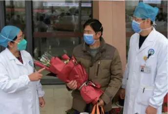  ??  ?? Zhang Wei (left), the President of the First Affiliated Hospital of Nanchang University in Jiangxi Province and a deputy to the National People’s Congress, talks with a discharged patient in the hospital on January 27