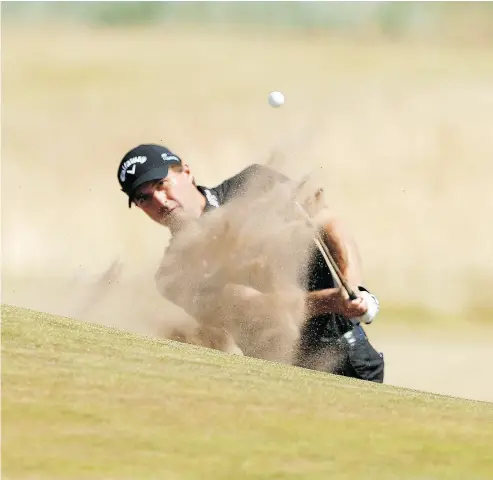  ?? ALASTAIR GRANT / THE ASSOCIATED PRESS ?? Kevin Kisner plays out of the bunker on the 17 th hole en route to a 5-under 66 lead on Day 1 of the British Open.