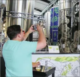  ?? WILSON RING — THE ASSOCIATED PRESS ?? Walter Richter, of New York City, makes a photograph during a visit to the Alchemist brewery in Stowe, Vt. The woods of northern New England are luring beer tourists. No discussion of beer in Vermont is complete without The Alchemist, a family run...