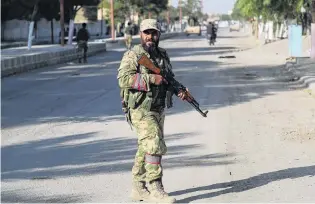  ?? PHOTO: REUTERS ?? A Turkeyback­ed Syrian fighter patrols in the town of Tal Abyad, at the Turkish border.