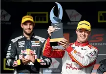  ??  ?? Scott Mclaughlin holds the winner’s trophy as Supercars title rival Shane van Gisbergen looks on.