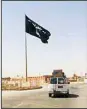  ?? ?? A motorist passes by a flag of the Islamic State group in central Rawah, 175 miles (281 kilometers) northwest of Baghdad, Iraq, July 22, 2014. Members of the global coalition fighting the Islamic State group met in Morocco on May 11, to discuss ongoing efforts in the campaign. (AP)