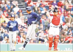  ?? Omar Rawlings / TNS ?? Avisail Garcia of the Tampa Bay Rays scores after a throwing error by second baseman Michael Chavis of the Boston Red Sox on Sunday at Fenway Park in Boston.