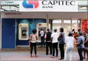  ?? PHOTO: REUTERS ?? Customers queue to draw money from an ATM outside a branch of South Africa’s Capitec Bank in Cape Town. Capitec has come under fire from Viceroy Research.