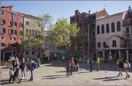  ?? GUS POWELL — THE NEW YORK TIMES ?? A square in the historic Jewish Ghetto in Venice, Italy, with the Italian Synagogue in pale pink, at right, on April 21. An $11million project is underway to restore three decaying synagogues in Venice and preserve the city’s history of harboring European Jews.