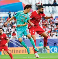  ?? — AFP photo ?? China’s Xie Pengfei (left) fights for the header with Lebanon’s defender Maher Sabra during the AFC Asian Cup Group A match at the Al-Thumama Stadium in Doha.
