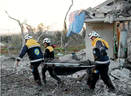  ?? AP ?? Syrian White Helmet civil defence workers carry the body of a victim past a destroyed house after Russian air strikes hit the village of Maaret Musreen in Syria’s Idlib province shortly before a ceasefire took effect.