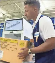  ??  ?? A Walmart worker uses the company’s new FAST Unloader system to unload a box coming into a store.