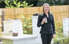  ?? Rebecca Droke/Post-Gazette ?? Michele Meloy Burchfield, co-founder and CEO of Blume Honey Water, visits the Burgh Bees community apiary Wednesday in Homewood.