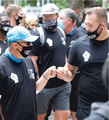  ?? AP ?? Broncos coach Vic Fangio (left) greets offensive lineman Dalton Risner before taking part in a march Saturday in Denver to protest the death of George Floyd. Fangio earlier had said he saw no racism in the NFL.