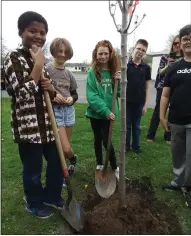  ?? ?? North Broad Elementary students, Abdul, left, and Annabella, center, help plant a tree Friday afternoon at Veterans Memorial Field.