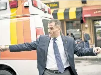  ??  ?? FIRST AID: Marc Molinaro calls 911 as he and another Good Samaritan tend to a man on the street Monday in Poughkeeps­ie, where the gov hopeful then directed traffic.