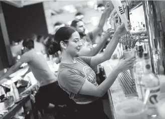  ?? Craig Hudson For the Washington Post ?? Bartender Vanessa Wade pours a beer at Takoda Navy Yard in Washington last month. Average hourly wages and the labor force participat­ion rate were both up by 0.3 percent last month.