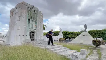  ?? — AFP photos ?? Mario Darias walks through graves at Colon Cemetery in Havana.