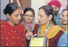  ?? PARDEEP PANDIT/HT ?? Congress candidate Jasleen Kaur Sethi showing her party symbol on a dummy EVM to a voter during a doortodoor campaign in Jalandhar on Thursday.