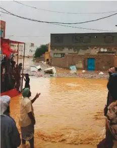  ??  ?? Yemenis in a flood-hit area in the eastern province of Mahra. The governor of the province has urged relief organisati­ons to offer assistance to the locals hit by tropical storm Luban.