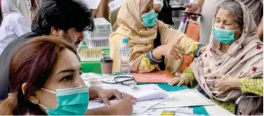  ?? Agence France-presse ?? ↑
Relatives of patients infected with dengue crowd the admission counter for bed allocation at a hospital in Lahore on Sunday.