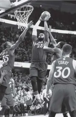  ??  ?? The Cleveland Cavaliers’ LeBron James dunks over the Golden State Warriors’ Kevin Durant on Sunday in Cleveland. James scored 31 points as the Cavs won 109-108. Jason Miller, Getty Images