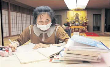  ??  ?? A Vietnamese migrant worker who lost her job amid the coronaviru­s outbreak studies Japanese language at the Nisshinkut­su Buddhist templ, which has turned into a shelter for young Vietnamese in Tokyo.