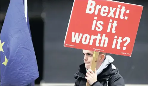  ?? | AP ?? A PROTESTER holds a banner in London. British politician­s overwhelmi­ngly rejected Prime Minister Theresa May’s divorce deal with the European Union on Tuesday, plunging the Brexit process into chaos.