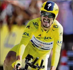  ?? CHRISTOPHE ENA / AP ?? France’s Julian Alaphilipp­e wearing the overall leader’s yellow jersey crosses the finish line to win Friday’s 13th stage of the Tour de France, an individual time trial over 16.9 miles in Pau, France.