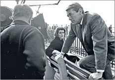  ??  ?? Gregory Peck and Diane Baker discuss a shot on the set of 1965’s Mirage in Battery Park, Lower Manhattan, New York