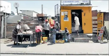  ?? PICTURE: HENK KRUGER ?? CALM: Residents of Masiphumel­ele near Fish Hoek get back to work in the area this week following a vigilante murder there last Sunday. The informal settlement has become so volatile police are worried about setting up a temporary community centre to...