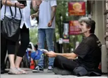  ?? JOHN RENNISON, THE HAMILTON SPECTATOR ?? Dwight Perry panhandlin­g in downtown Hamilton. He has amassed more than $20,000 worth of tickets from Hamilton police.