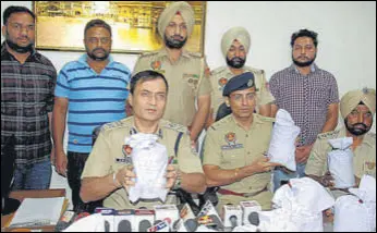  ?? HT PHOTO ?? Police with the seized contraband in Amritsar on Tuesday.