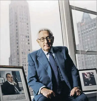  ?? MICHELINE PELLETIER DECAUX / GETTY ?? Kissinger, en su oficina de Manhattan, con los retratos de Nixon y Ford, presidente­s a los que sirvió