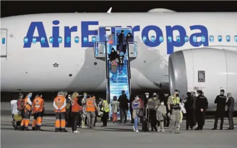  ?? // EFE ?? Los refugiados descienden del avión de Air Europa, anoche en la base de Torrejón de Ardoz (Madrid)