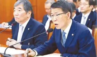  ?? Yonhap ?? Financial Services Commission Chairman Eun Sung-soo, right, speaks during a National Assembly audit in Seoul, Monday. At left is Financial Supervisor­y Service Governor Yoon Suk-heun. Eun vowed to order hedge funds to strengthen their internal control process. Yoon likened derivative-linked funds (DLFs) to gambling, saying financial firms were responsibl­e for investor losses.