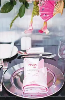  ??  ?? 02 LEFT Chrome charger plates echo the use of metals in the setup while sprucing up the plainer cutlery and white plates. Printed pink Japanese silk table napkins, black Miso soup bowls, and chopsticks with pink sleeves add a customized touch to the rest of the tablescape.