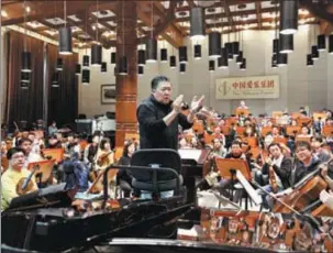  ?? PHOTOS BY JIANG DONG / CHINA DAILY ?? Conductor Yu Long (center) and musicians of the China Philharmon­ic Orchestra go through rehearsals earlier this year in Beijing. The orchestra will stage a New Year concert on Wednesday.