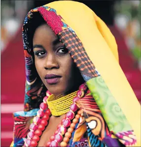  ?? Picture: AFP ?? MAGIC OF COLOUR: A model displays the creation of a South African designer during the fashion show at the Vodacom Durban July