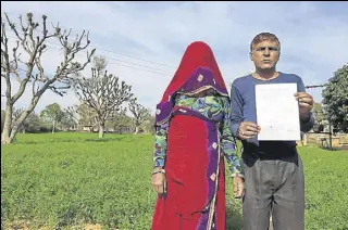  ?? ZIA HAQ /HT ?? Tulcha Ram (right) holds the notice to auction his land for failing to pay his farm loan.