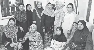  ??  ?? RAIKAN BERSAMA: Nurhanim (berdiri, tiga kanan) bersama golongan wanita pada rumah terbuka Hari Raya Aidilfitri di salah satu cawangan PKR di Kuching, baru-baru ini.