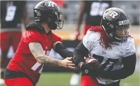  ?? TONY CALDWELL ?? Running back Timothy Flanders, right, takes a handoff on day two of the Ottawa Redblacks' training camp at TD Place on Monday. “It was one of the reasons I signed with Ottawa, getting that chance,” Flanders said.