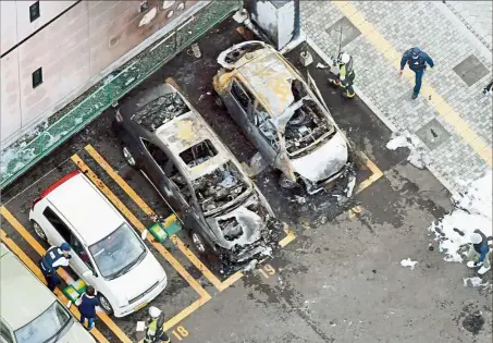  ??  ?? Burnt out: Police inspecting the parking lot in Utsunomiya where one of the explosions caused a fire. — Reuters