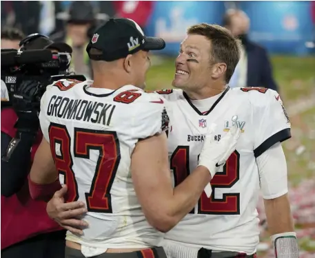  ?? AP FILE PHOTOS ?? WINNING FORMULA: Buccaneers quarterbac­k Tom Brady, right, and tight end Rob Gronkowski celebrate after defeating the Chiefs in Super Bowl LV at Raymond James Stadium in Tampa, Fla., on Feb. 7. At top, Bucs general manager Jason Licht, right, celebrates the Super Bowl victory with coach Bruce Arians on Feb. 10 in Tampa.