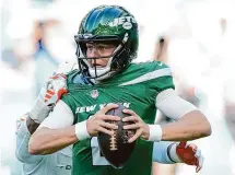  ?? Rebecca Blackwell/Associated Press ?? New York Jets quarterbac­k Zach Wilson looks for a chance to pass, just before getting sacked by Miami Dolphins linebacker Bradley Chubb on Dec. 17 in Miami Gardens, Fla.