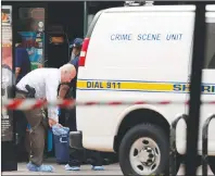  ?? AP PHOTO ?? A law enforcemen­t investigat­or puts protective covers over his feet Monday before entering a building that was the scene of mass shooting at The Jacksonvil­le Landing in Jacksonvil­le, Fla.