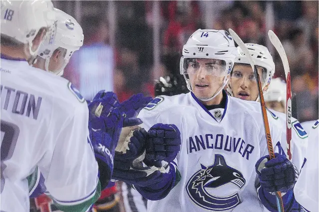  ?? DEREK LEUNG/ GETTY IMAGES ?? Alex Burrows celebrates after scoring against the Calgary Flames on Wednesday in Calgary. Between injuries last year, he went 35 games without a goal, did not score until March 12 and fi nished the season with only fi ve goals in 49 games. Burrows says...