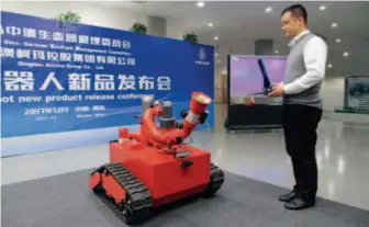  ??  ?? December 5, 2017: An engineer displays an intelligen­t robot for special firefighti­ng, co-produced by Siemens and China’s Qingdao Aucma Group. VCG