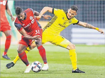  ?? AP PHOTO ?? Columbus Crew midfielder Artur (7) tangles with Toronto FC midfielder Armando Cooper (31) during the first half of an MLS soccer match in Columbus, Ohio, Saturday. After a disappoint­ing loss in Columbus that turned a five-game unbeaten streak into a...